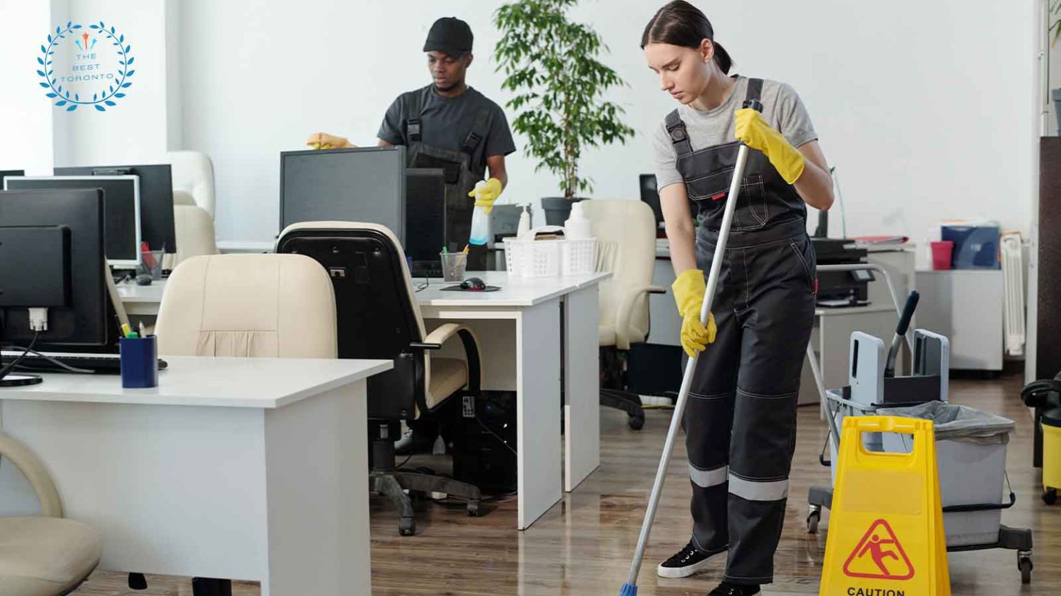 A woman cleans an office floor with a mop, utilizing a yellow bucket to assist in her cleaning efforts.